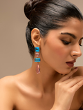Model wearing handcrafted blue and pink crystal drop earrings, showcasing their vibrant color and elegant design.