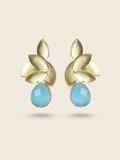 Stylish gold-toned earrings with overlapping leaf motifs and a smooth, oval-shaped blue gemstone drop.