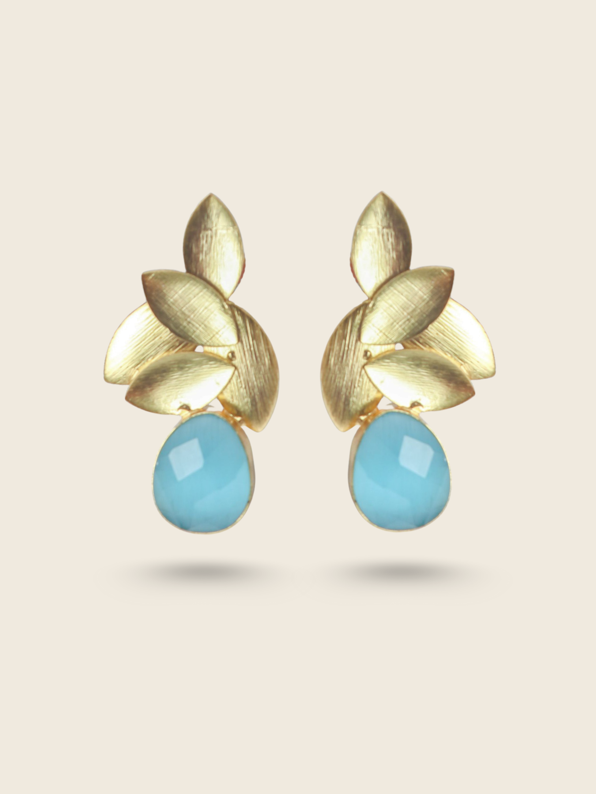 Stylish gold-toned earrings with overlapping leaf motifs and a smooth, oval-shaped blue gemstone drop.